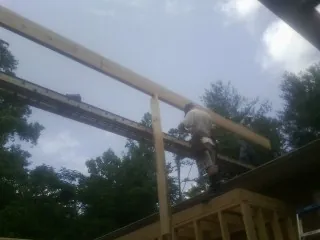 Carpenter setting a ridge beam over a new addition frame — Ice Dam Removal by Roofing Brothers in Jonesburg