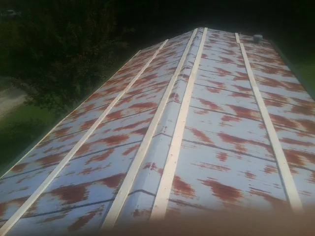 Rusted metal roof panels with new wood purlins before replacement — Storm Damage Roof Repair in Jonesburg by Roofing Brothers